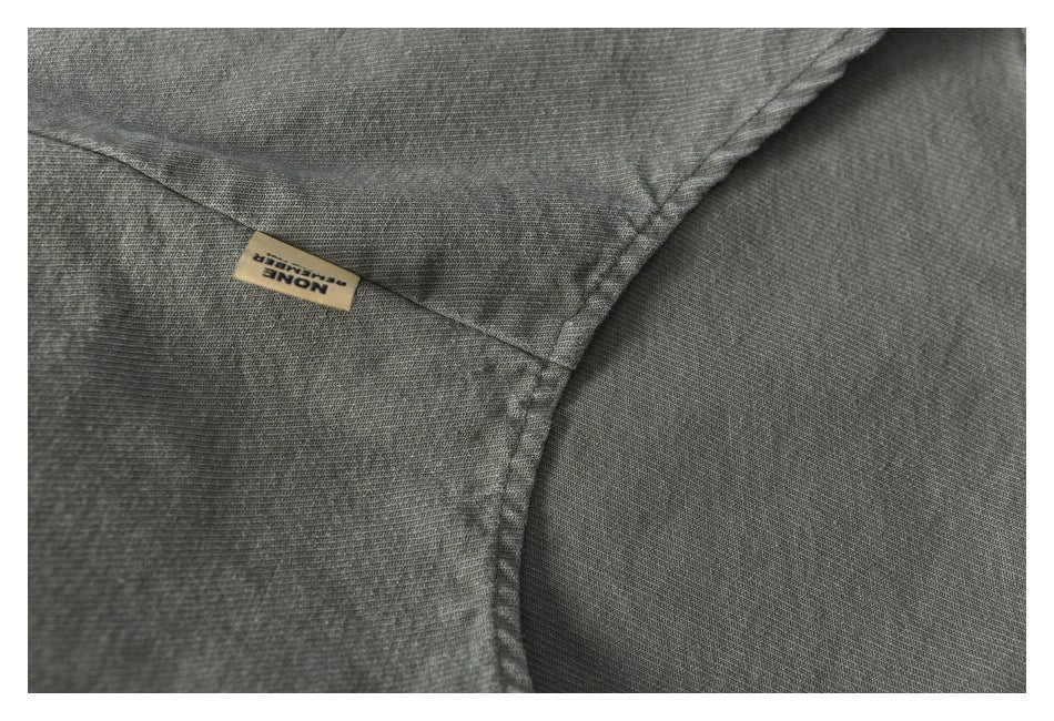 Close-up of a gray garment seam and small beige woven label with English text.
