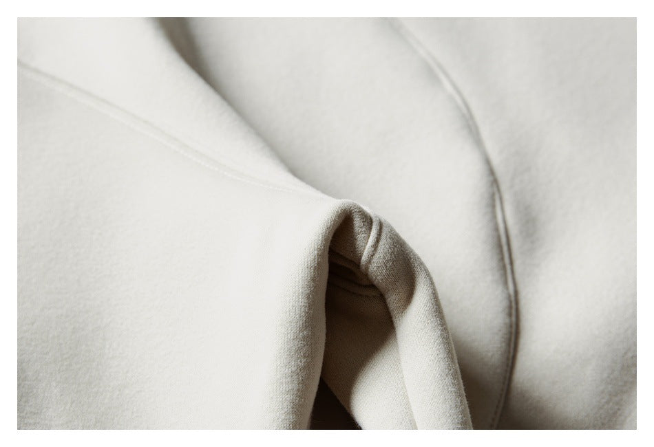 Close-up of a cream sweatshirt sleeve and stitched seam.