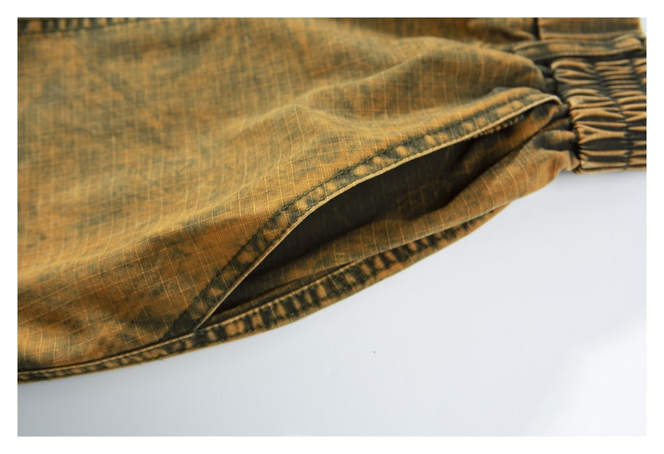 Close-up of the ochre-brown pants' elasticized waistband and stitched fabric edge.