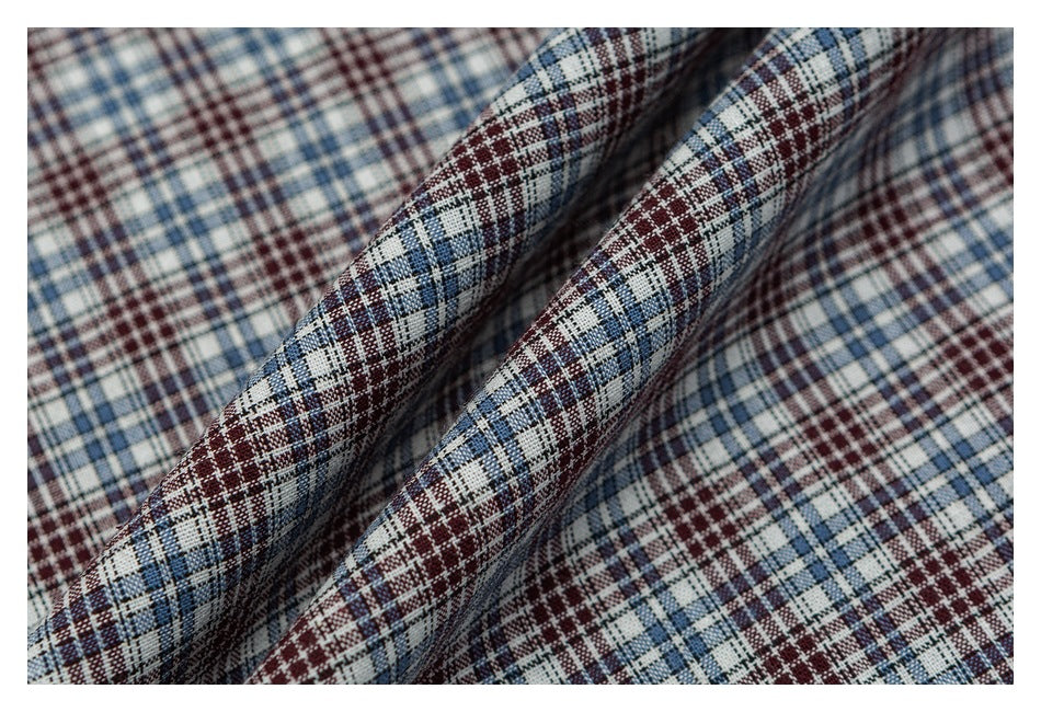 Close-up of blue, burgundy, and white plaid shirt fabric arranged in soft folds.