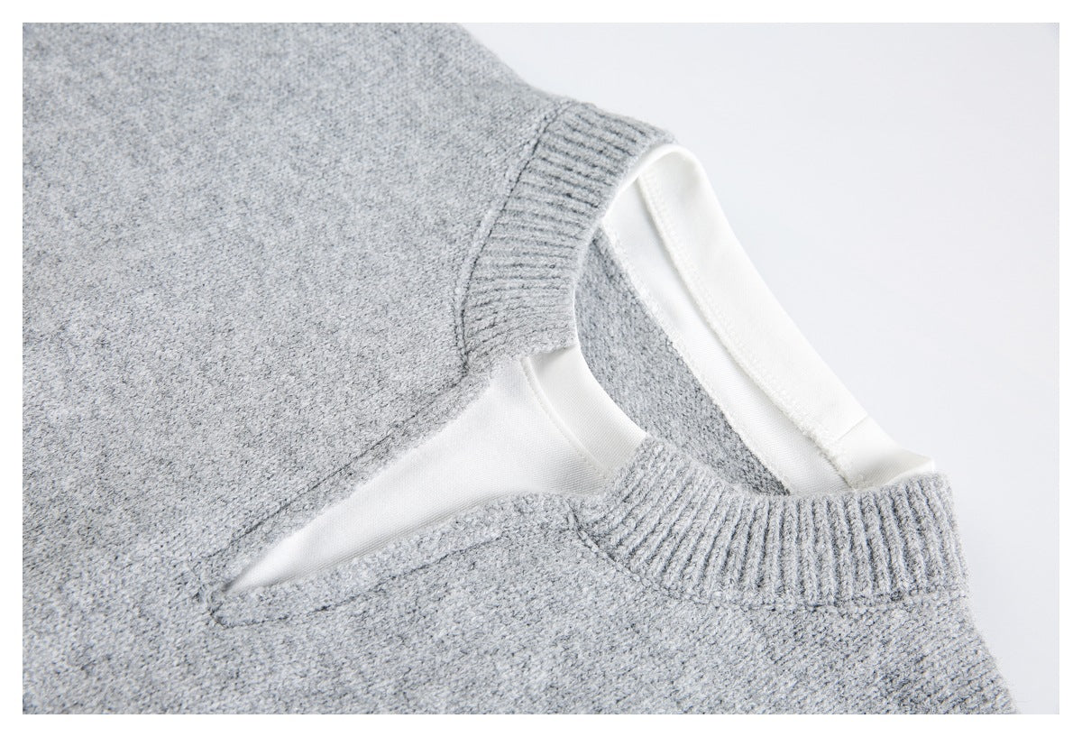 Close-up of a light gray knit sweater's neckline, with ribbed trim and white inner facing.