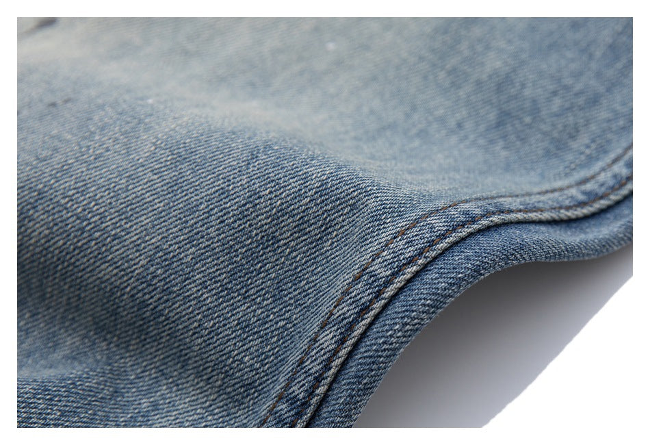 Close-up of blue denim fabric and a curved double-stitched seam.