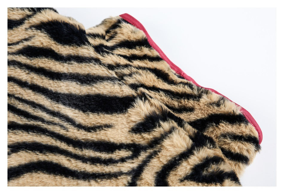 Close-up of tan-and-black tiger-striped faux fur and a burgundy-bound edge.
