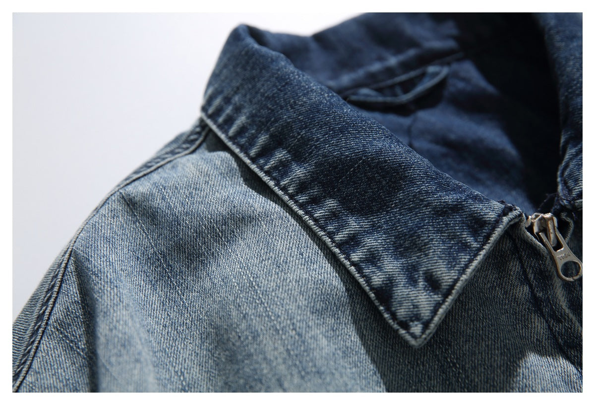 Close-up of a blue denim jacket collar and metal zipper with a contrasting faded wash.