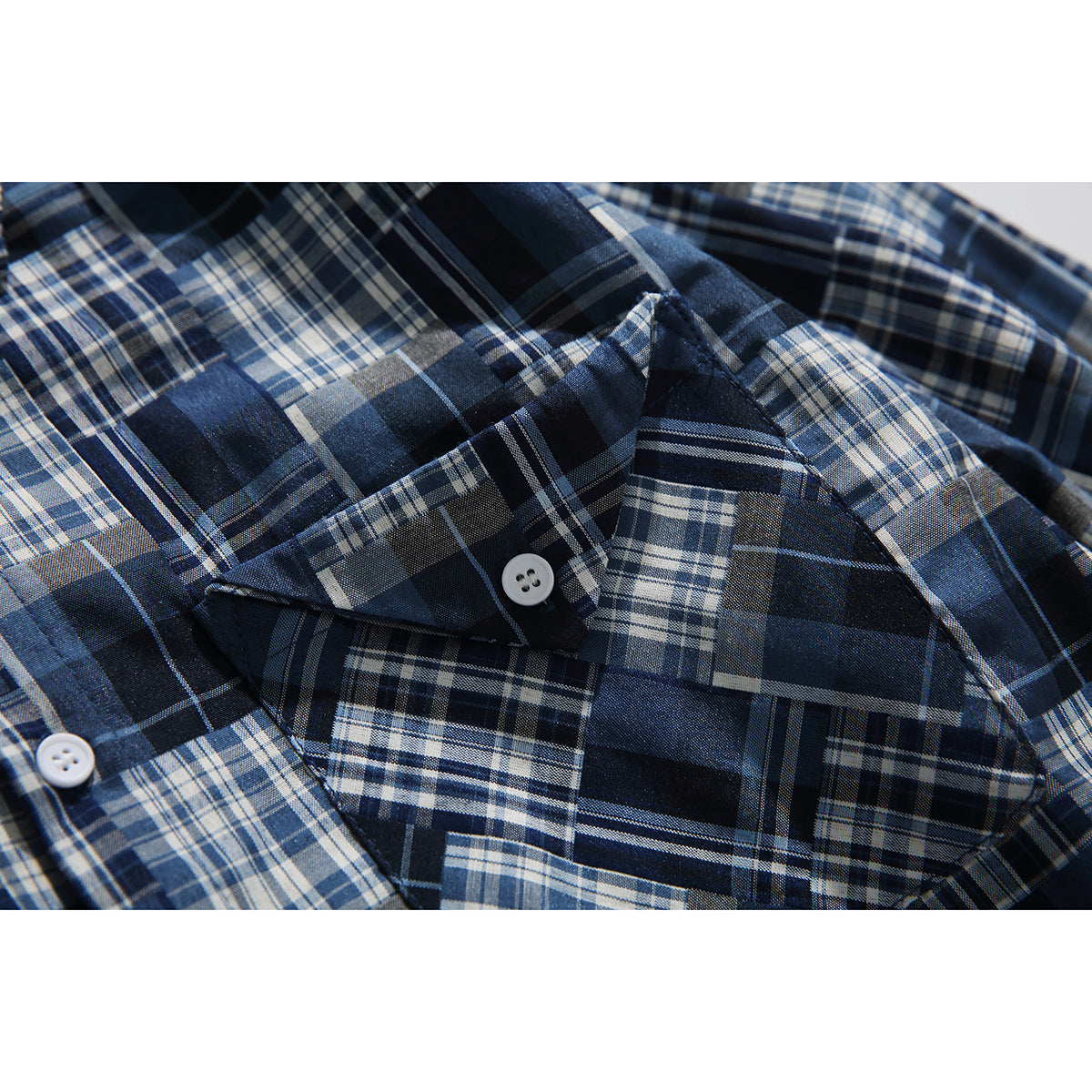 Close-up of the shirt's plaid chest pocket, button, and intersecting navy, blue, gray, and white checks.