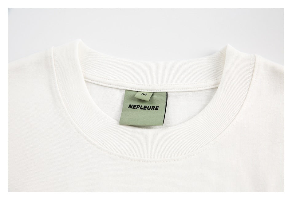 Close-up of an off-white crew neck shirt collar and sewn size M brand label.