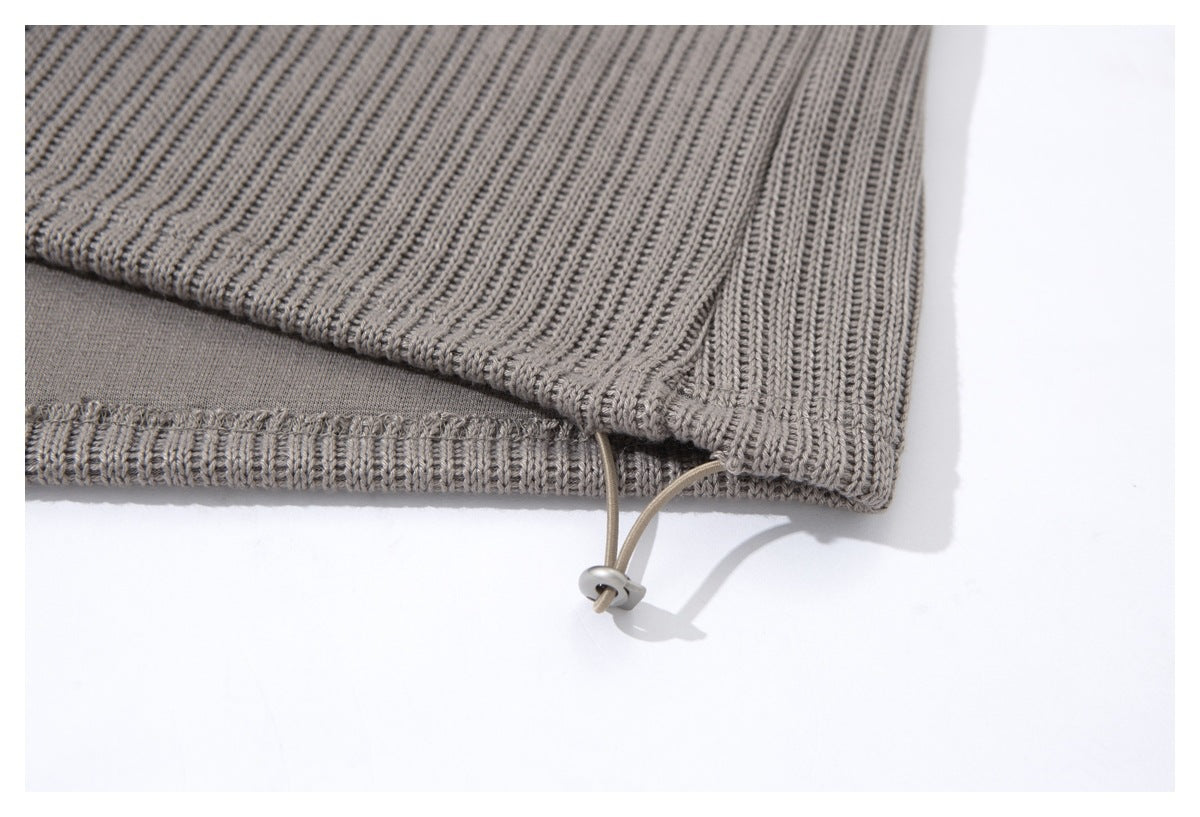 Close-up of the gray ribbed top’s hem with an adjustable drawcord and toggle.