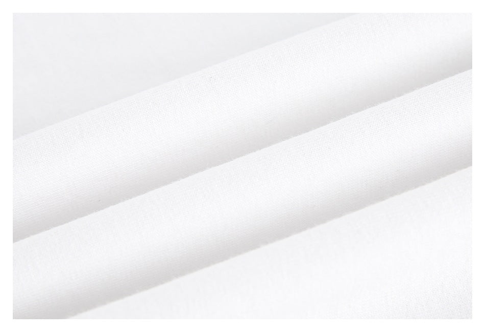 Extreme close-up of white garment fabric folded into soft ridges.