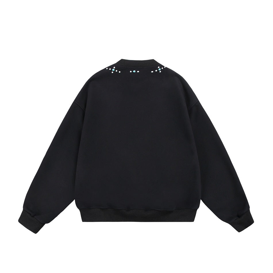 Back view of a black crewneck sweatshirt with turquoise and white embellishments near the neckline.