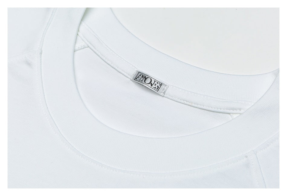 Close-up of the white T-shirt’s crew neckline and sewn-in neck label.