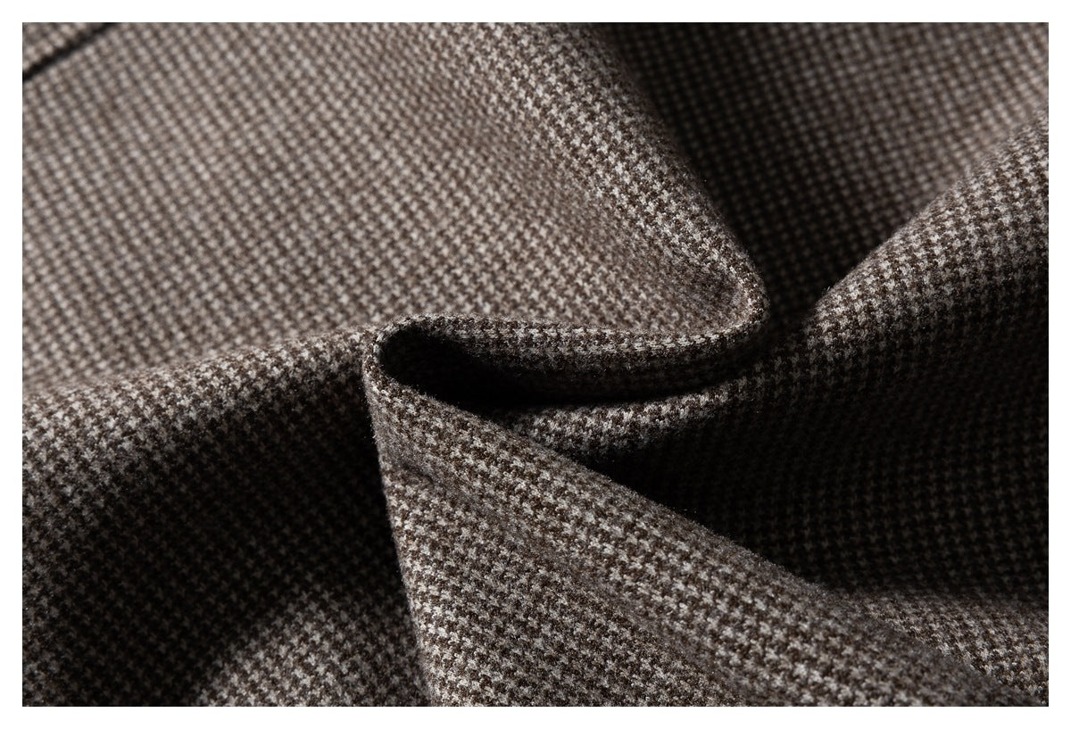 Close-up of brown and gray houndstooth fabric folded to show its texture.