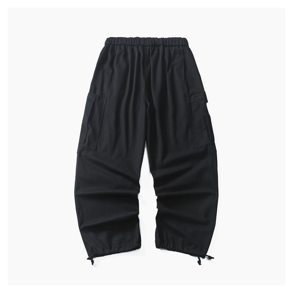 Black loose-fit cargo pants with an elastic waistband, side pockets, and adjustable ankle drawcords, shown flat.