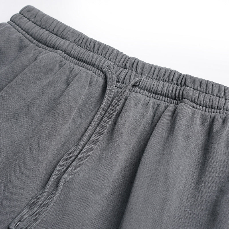 Close-up of gray shorts showing the elastic waistband and matching drawstring.