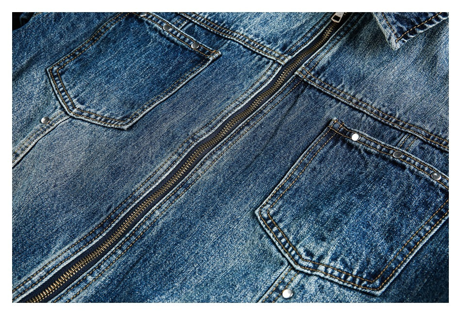 Close-up of a blue denim jacket front with two pockets, rivets, and a metal zipper.