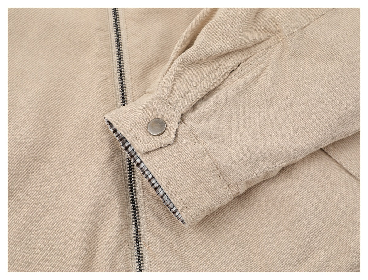 Close-up of the beige jacket's snap-button cuff with checked lining visible at the edge.