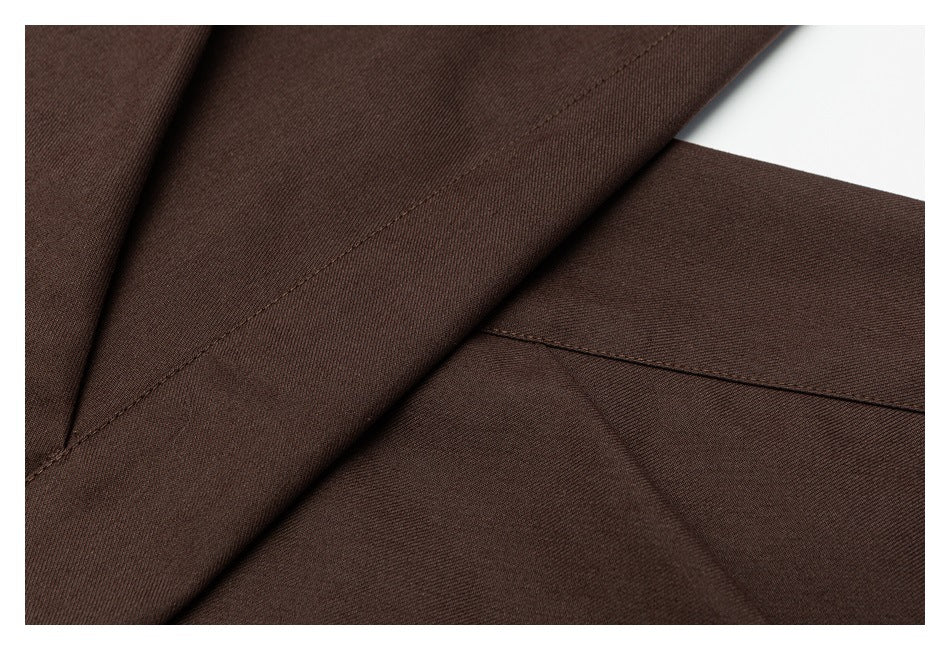 Close-up of brown garment fabric with diagonal stitching and intersecting seams.