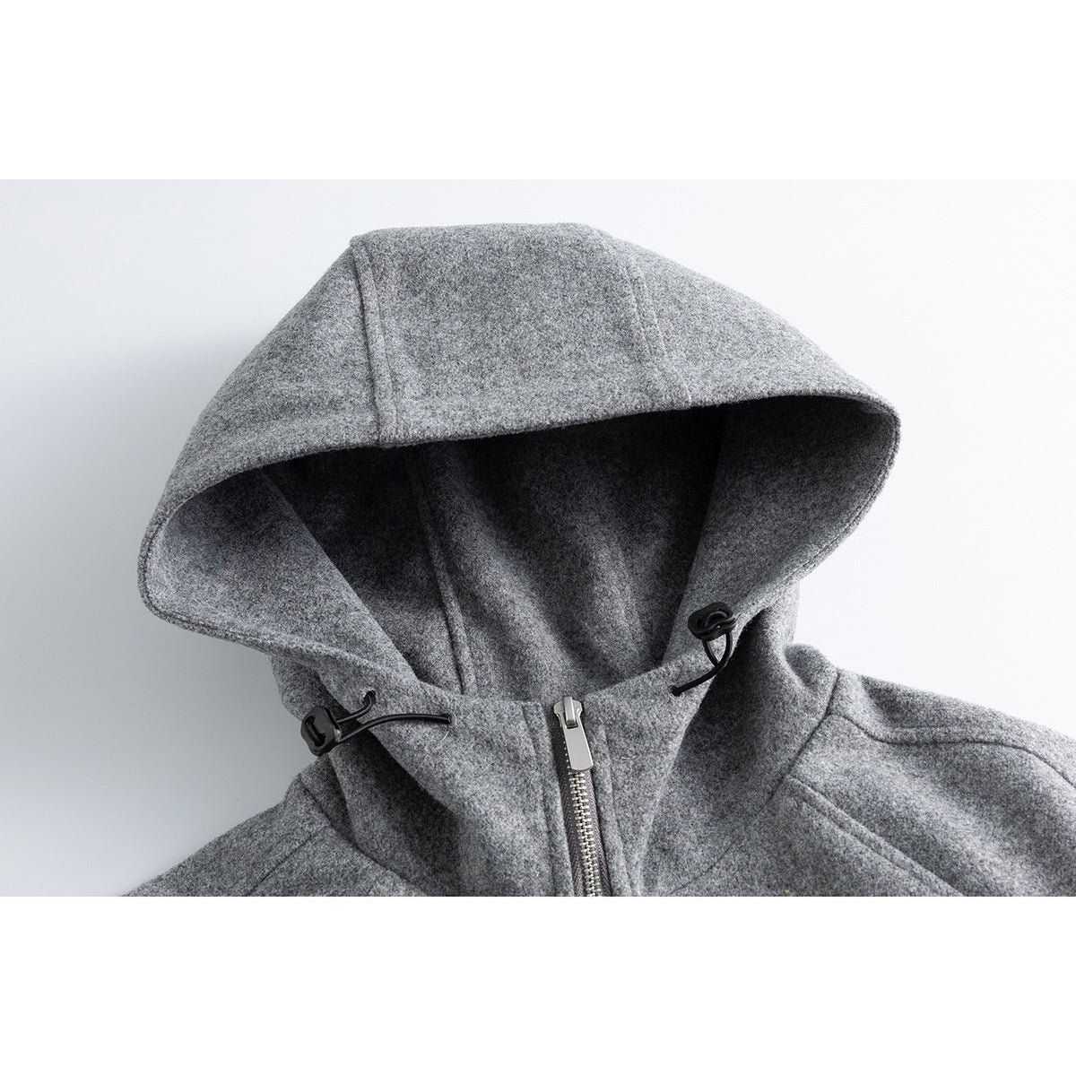 Close-up of a gray hooded jacket showing the lined hood, drawcord toggles, and front zipper.