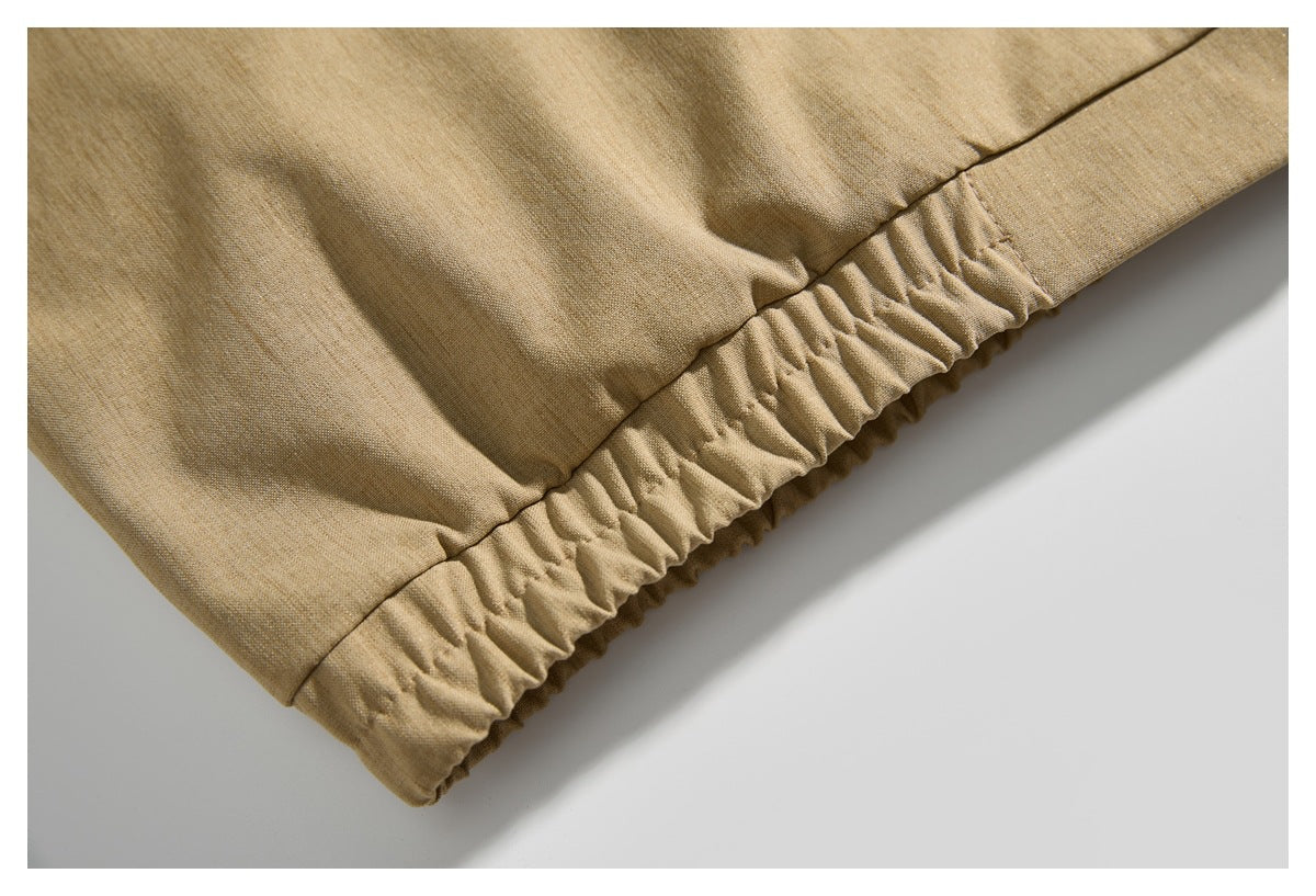 Close-up of the gathered elastic hem on a tan jacket.