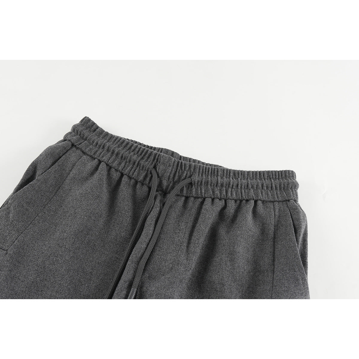 Close-up of charcoal gray pants showing the gathered elastic waistband and long drawstring.