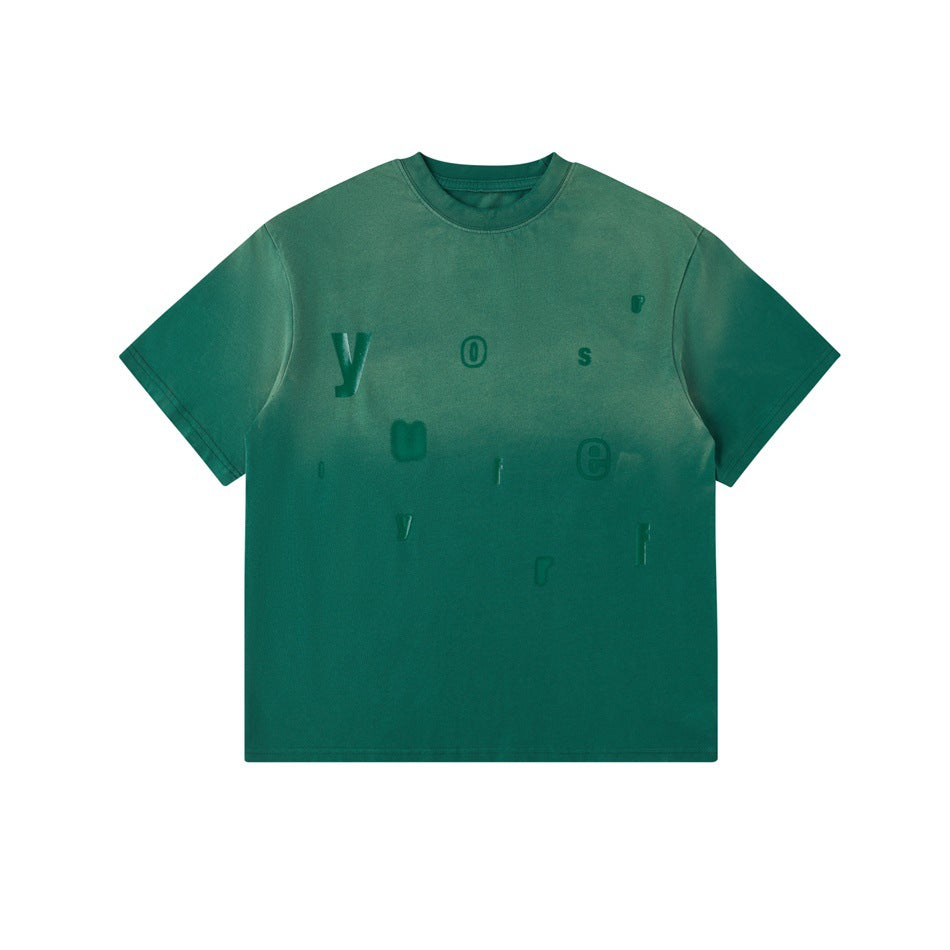Green washed gradient crew-neck T-shirt with scattered tonal raised letters on the front, flat lay
