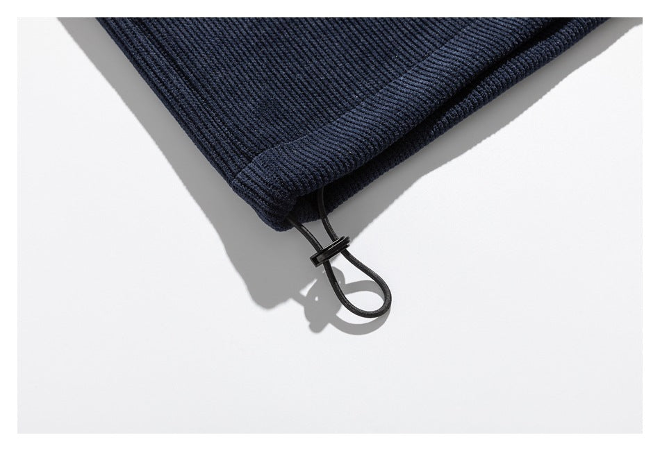 Close-up of a dark navy ribbed garment hem with an adjustable black drawcord and toggle.
