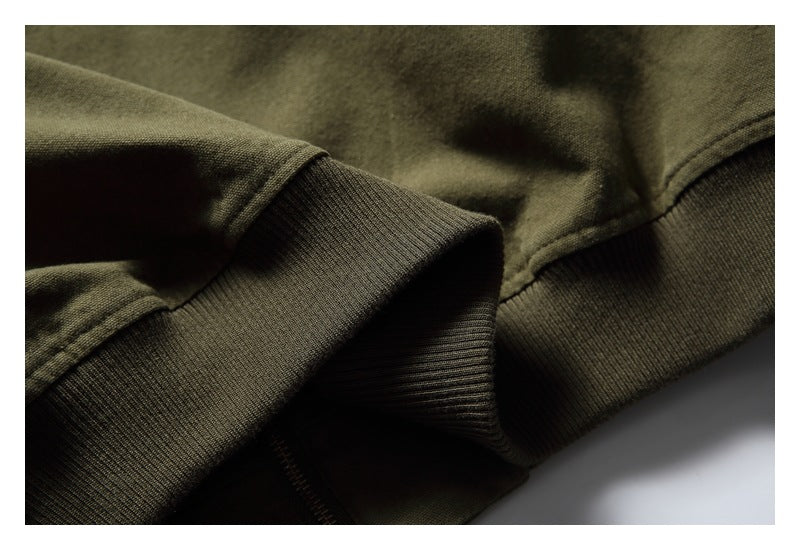 Close-up of a dark ribbed cuff and matching olive garment hem.
