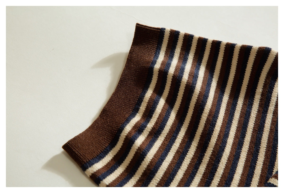 Close-up of a brown ribbed sleeve cuff and cream, brown, and navy striped knit fabric.