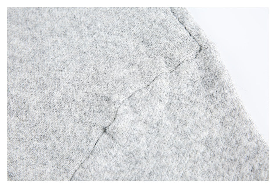 Close-up of a seam joining light gray knit panels.