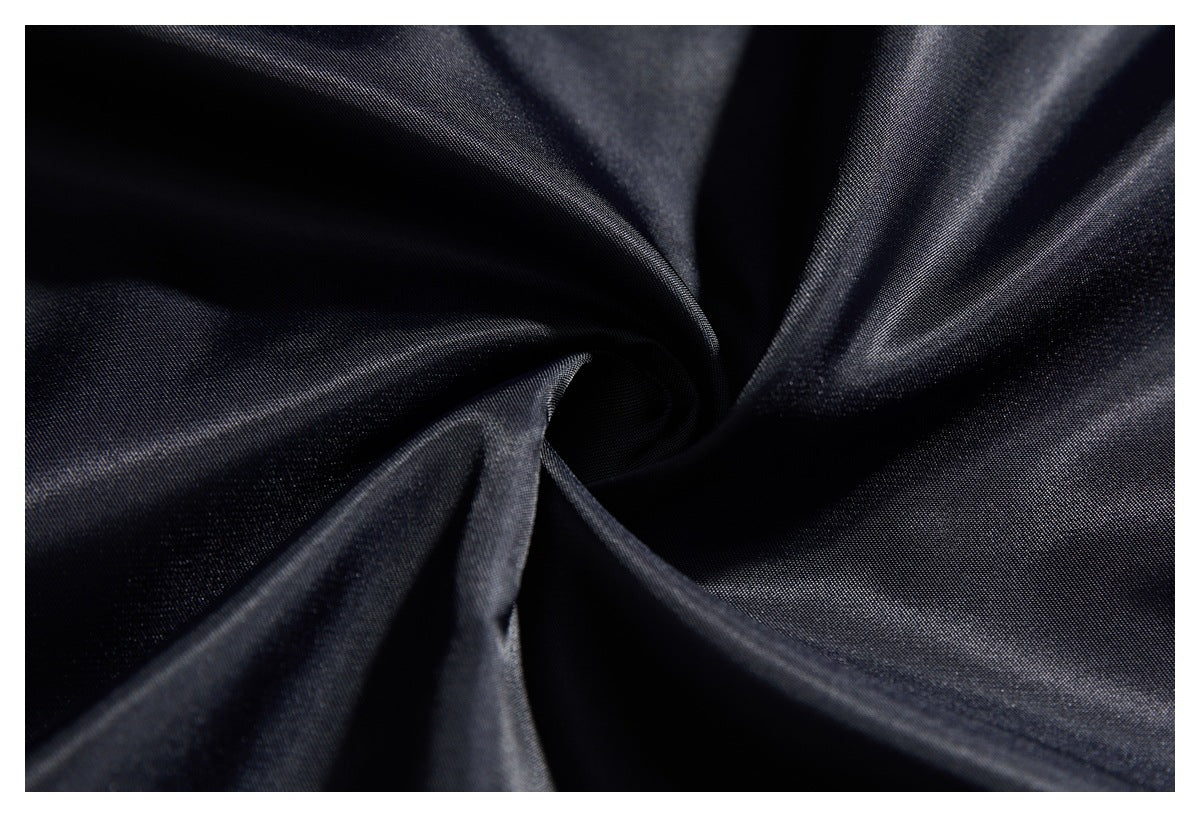 Close-up of dark fabric gathered into soft folds, showing its subtle surface texture.