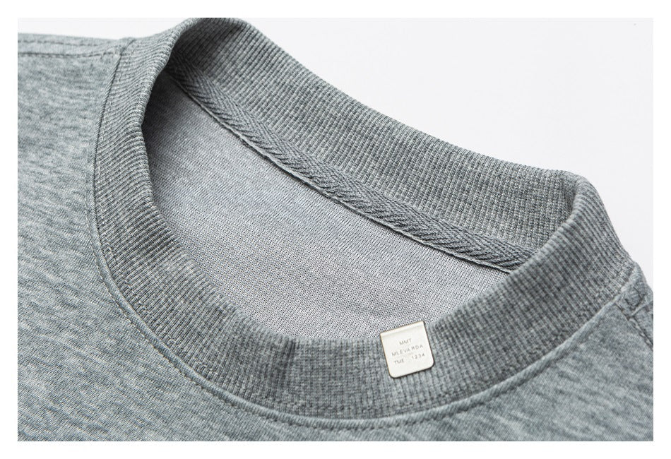 Close-up of a gray sweatshirt's ribbed crew neckline, inner stitching, and small neck label.