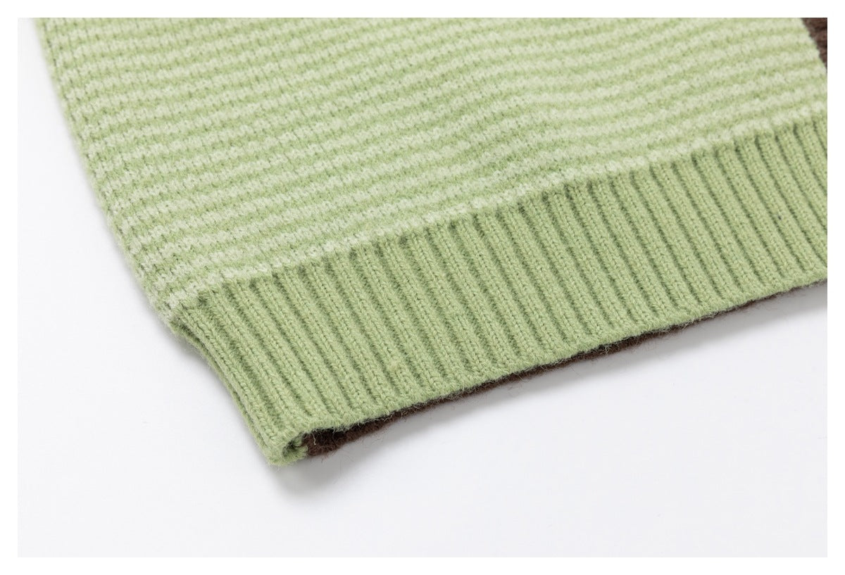 Close-up of a pale green striped knit garment showing its wide ribbed hem.