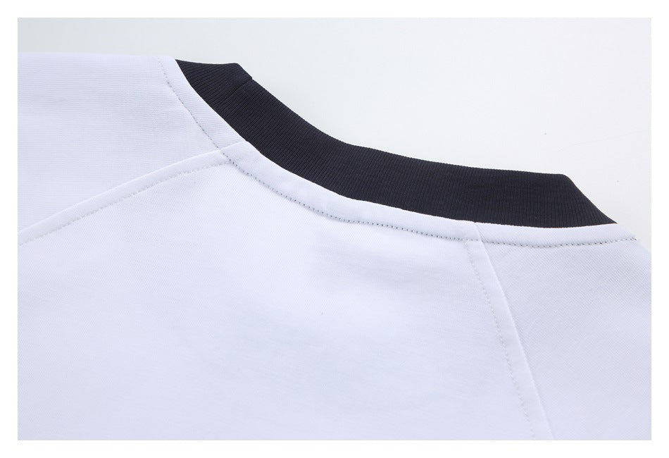 Close-up of a white garment's neckline with a contrasting black ribbed collar.