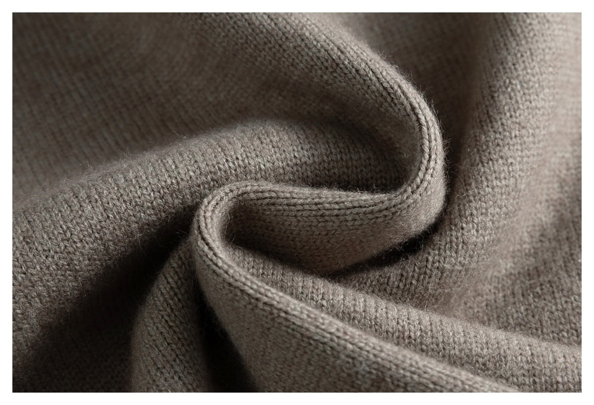 Close-up of soft taupe-gray knit fabric folded into curved layers.