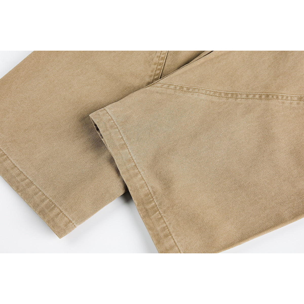 Close-up of tan trouser legs showing the fabric, seams and finished hems.