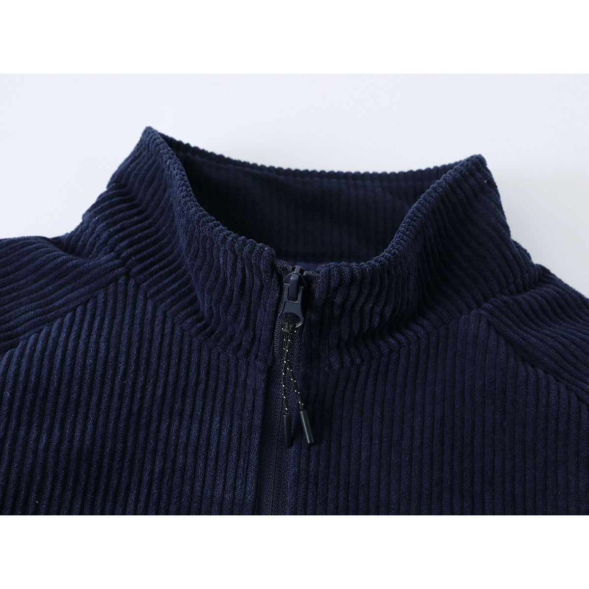 Close-up of a navy ribbed jacket's raised collar and front zipper.