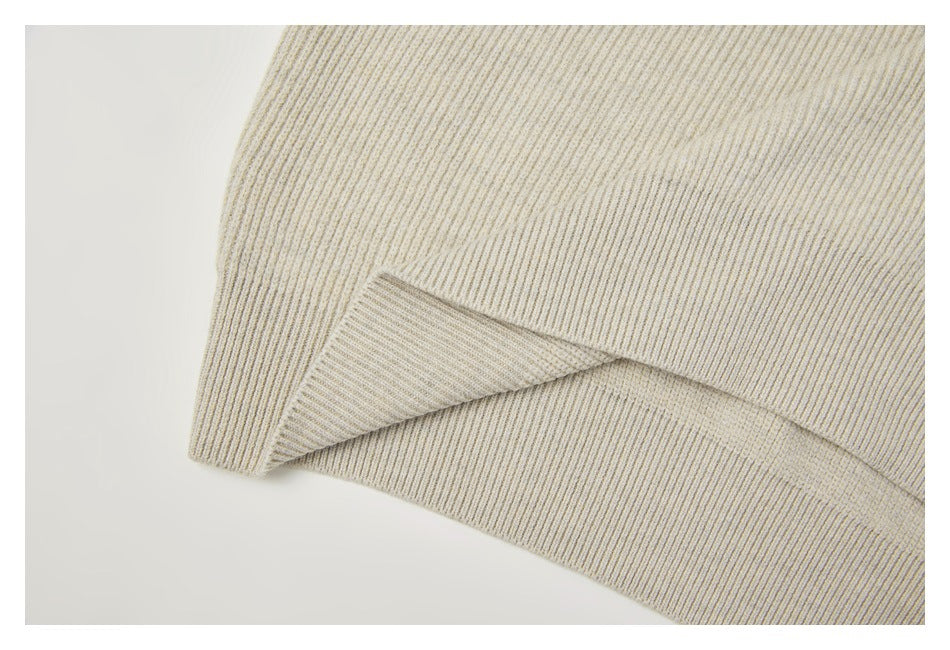 Close-up of the cream rib-knit garment's hem and ribbed edge.