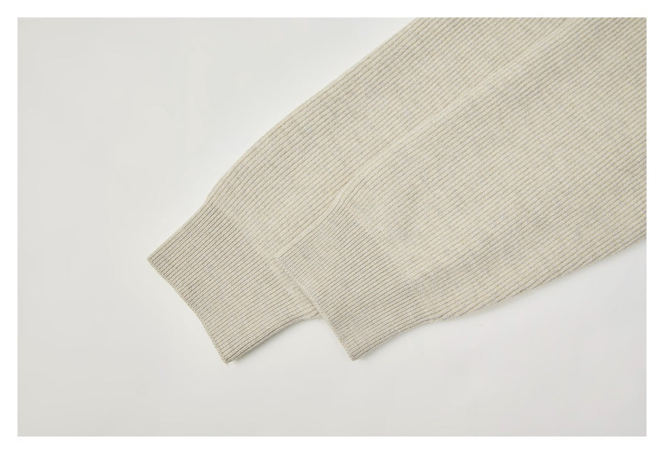 Close-up of a cream rib-knit sleeve ending in a wide ribbed cuff.