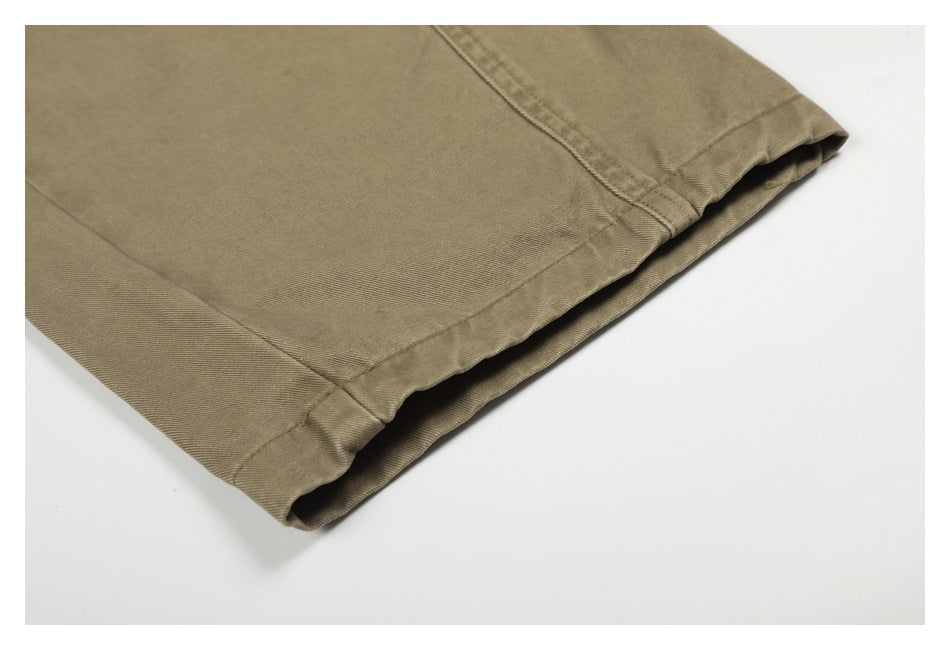 Close-up of the taupe trousers' wide-leg hem and stitched edge.
