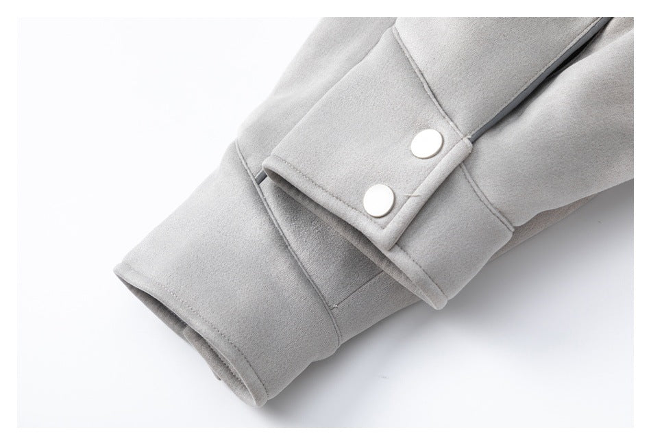 Close-up of a light gray jacket cuff with two white snaps and dark piping.