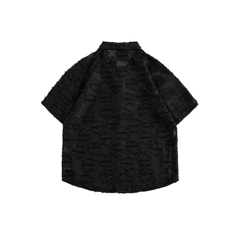 Back view of a black short-sleeve collared shirt with a raised floral pattern.