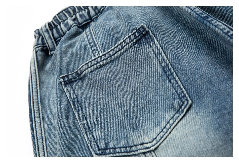 Close-up of a single back pocket and double stitching on blue jeans.