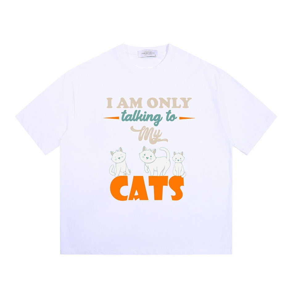 White short-sleeve crew-neck T-shirt with 'I AM ONLY talking to My CATS' graphic and three cartoon cats, flat lay