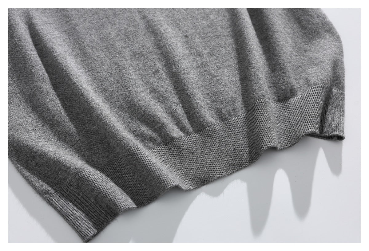 Close-up of the gray sweater's ribbed bottom hem against a white background.