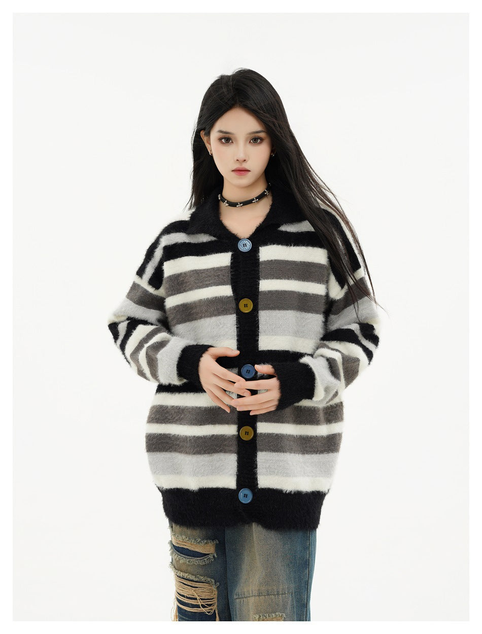 Model wearing the black, gray and white striped collared button cardigan with ripped jeans, front view