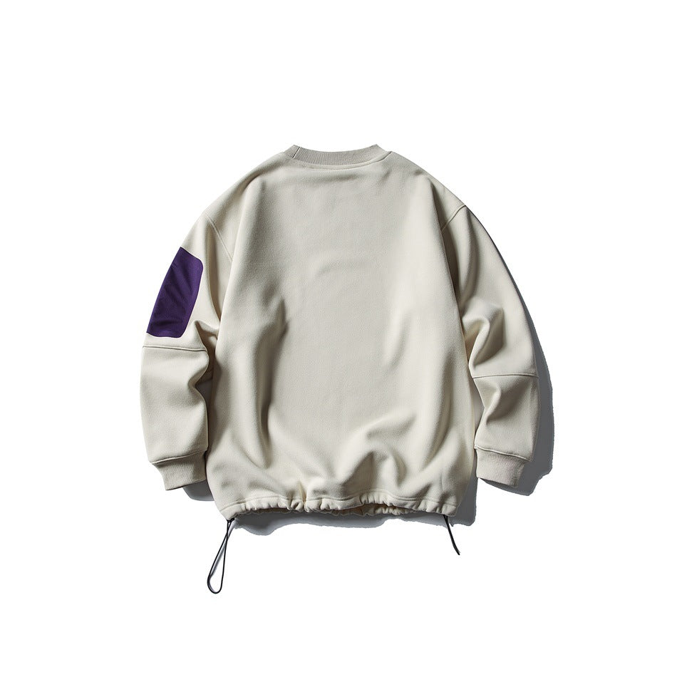 Back view of beige crewneck sweatshirt with purple sleeve patch and drawcord hem