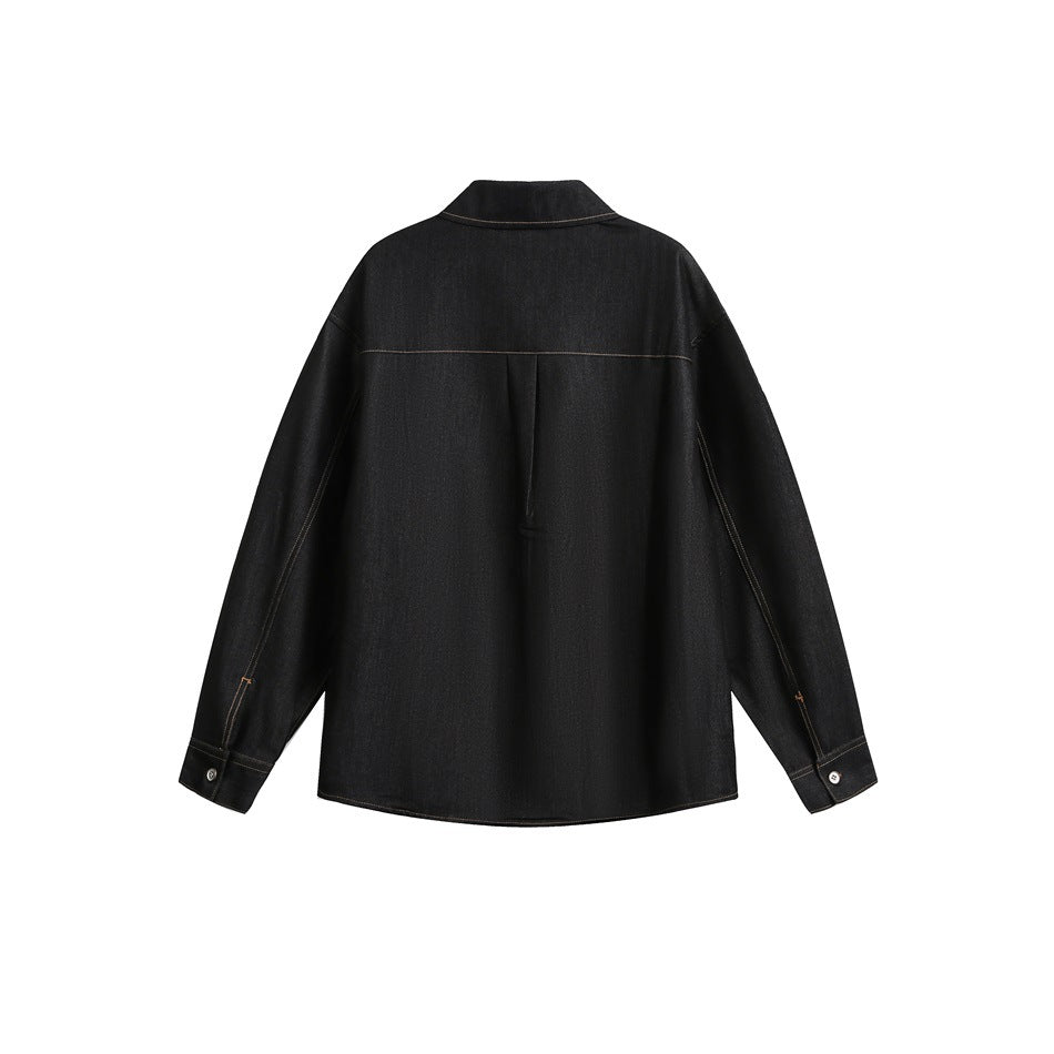 Back view of a black long-sleeve denim shirt with a pointed collar, center pleat, and button cuffs.