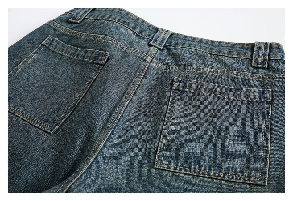 Close-up of blue faded jeans showing the waistband, belt loops, center seam, and two back pockets.