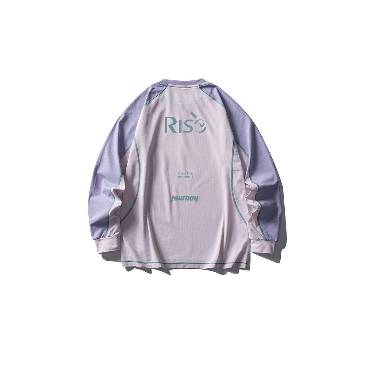 Back of a light pink long-sleeve raglan tee with lavender sleeves, teal stitching and a RISE print