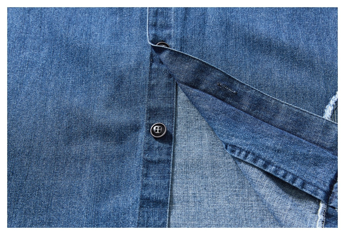 Close-up of the blue denim shirt's button placket, showing its underside and stitching.