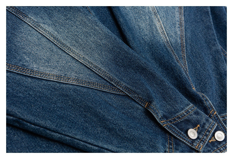 Close-up of overlapping blue denim panels, seam stitching, and silver snap buttons.